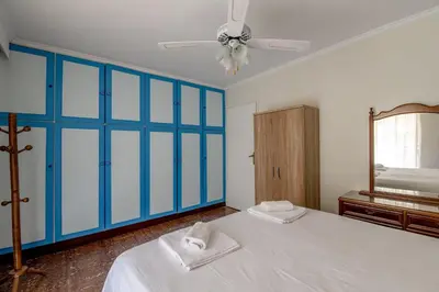 a bedroom with blue walls and a bed and a mirror at Evie's cozy apartment in Athens