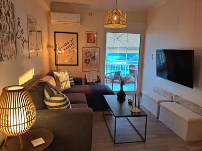 a living room with a couch and a table at Amazing sea view apartment in Lagonissi in Kalívia Thorikoú
