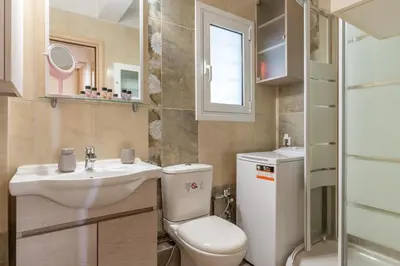 a small bathroom with a toilet and a sink at Amazing sea view apartment in Lagonissi in Kalívia Thorikoú