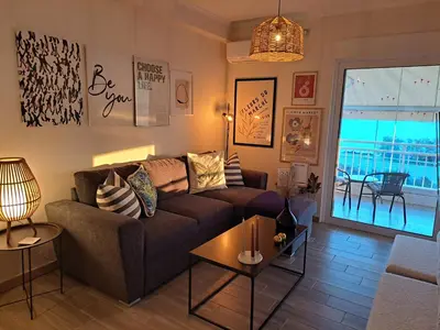 a living room with a couch and a table at Amazing sea view apartment in Lagonissi in Kalívia Thorikoú