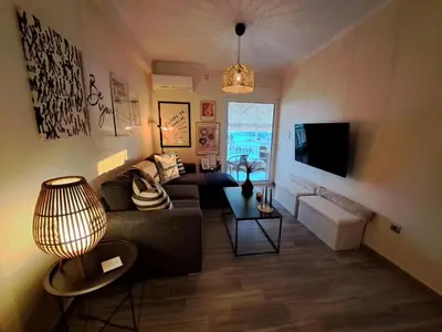 a living room with a couch and a tv at Amazing sea view apartment in Lagonissi in Kalívia Thorikoú