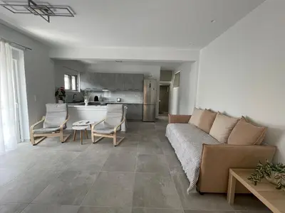a living room with a couch and chairs and a kitchen at Daniel's House - Palaia Fokaia in Palaiá Fókaia