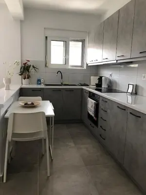 a kitchen with a table and a small table in it at Daniel's House - Palaia Fokaia in Palaiá Fókaia
