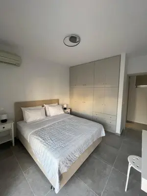 a bedroom with a large bed with white sheets at Daniel's House - Palaia Fokaia in Palaiá Fókaia