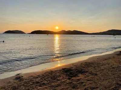 a beach with the sun setting over the water at Daniel's House - Palaia Fokaia in Palaiá Fókaia