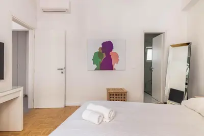 a white bedroom with a bed with towels on it at 3 bedroom New Modern Flat in the heart of Athens in Athens
