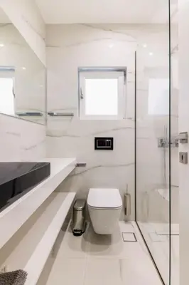 a white bathroom with a toilet and a window at 3 bedroom New Modern Flat in the heart of Athens in Athens