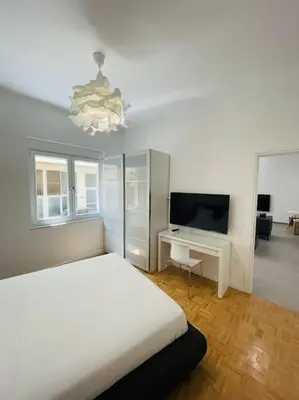 a bedroom with a bed and a desk and a television at 3 bedroom New Modern Flat in the heart of Athens in Athens