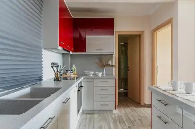 a kitchen with a sink and red cabinets at Fantastic sea view one-bedroom apartment - Lagonissi in Lagonissi
