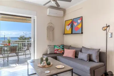 a living room with a couch and a table at Fantastic sea view one-bedroom apartment - Lagonissi in Lagonissi