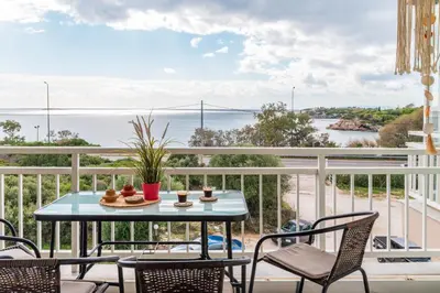 a table on a balcony with a view of the ocean at Fantastic sea view one-bedroom apartment - Lagonissi in Lagonissi