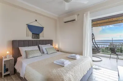 a bedroom with a bed with a view of the ocean at Fantastic sea view one-bedroom apartment - Lagonissi in Lagonissi