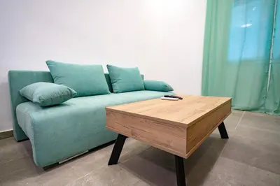 a green couch with pillows and a wooden coffee table at Koukaki 1 bedroom 4 persons apartment by MPS in Athens
