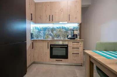 a kitchen with wooden cabinets and a refrigerator at Koukaki 1 bedroom 4 persons apartment by MPS in Athens