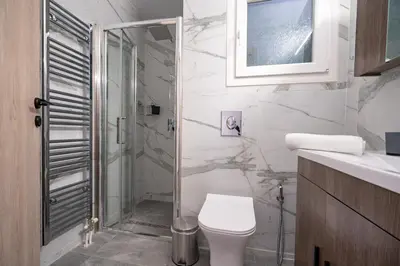 a bathroom with a toilet and a glass shower at Koukaki 1 bedroom 4 persons apartment by MPS in Athens
