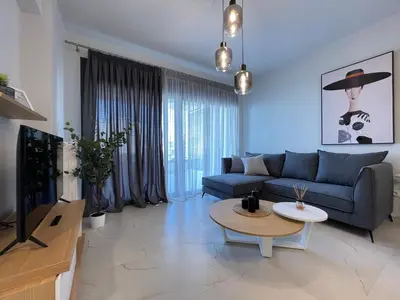 a living room with a blue couch and a table at Athenean Oasis in Ellinikon in Athens
