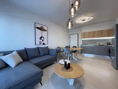 a living room with a blue couch and a table at Athenean Oasis in Ellinikon in Athens