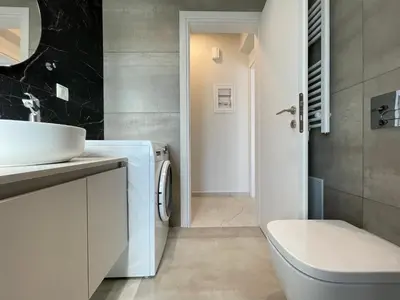 a bathroom with a sink and a washing machine at Athenean Oasis in Ellinikon in Athens