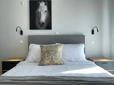 a bedroom with a bed with a horse picture on the wall at Athenean Oasis in Ellinikon in Athens