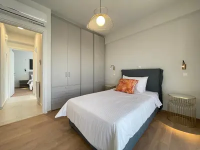 a bedroom with a large bed and a table at Athenean Oasis in Ellinikon in Athens