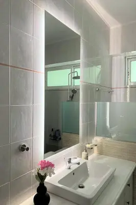 a white bathroom with a sink and a mirror at Sea, La Vie in Saronida