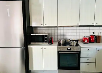 a kitchen with white cabinets and a stove and a microwave at Sea, La Vie in Saronida