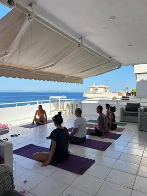 a group of people sitting on the floor doing yoga at Sea, La Vie in Saronida