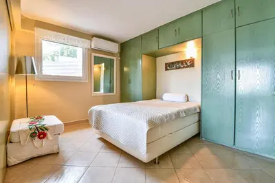 a bedroom with a large bed and green cabinets at Beachside Bungalows in Athens
