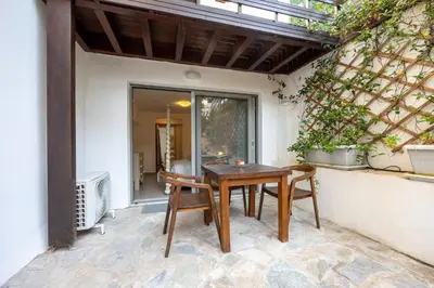 a patio with a wooden table and chairs at Beachside Bungalows in Athens