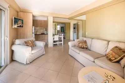 a living room with two white couches and a kitchen at Beachside Bungalows in Athens