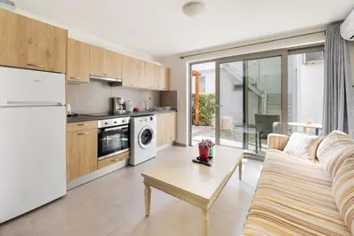 a kitchen and living room with a couch and a table at Beachside Bungalows in Athens