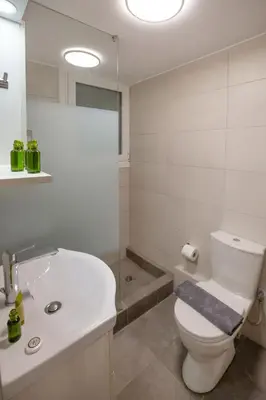 a white bathroom with a toilet and a sink at Beautiful apt near the sea by GHH in Athens