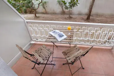 a balcony with a table and two chairs and a book at Beautiful apt near the sea by GHH in Athens