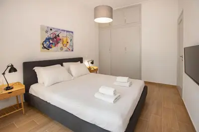 a bedroom with a bed with two towels on it at Beautiful apt near the sea by GHH in Athens