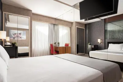 a hotel room with a large white bed and a desk at Lacoba Hotel in Athens