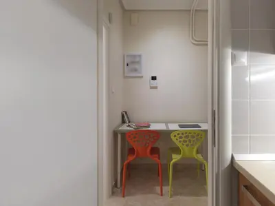 a kitchen with two colorful chairs and a table at AnapironPolemou5-Eleutheriou in Athens
