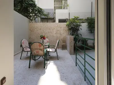 a patio with a table and chairs on a balcony at AnapironPolemou5-Eleutheriou in Athens