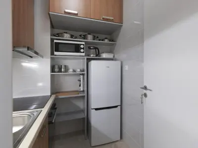 a kitchen with a white refrigerator and a microwave at AnapironPolemou5-Eleutheriou in Athens
