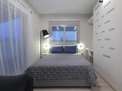 a bedroom with a bed with blue pillows and a window at Iliodorou2-4 in Athens