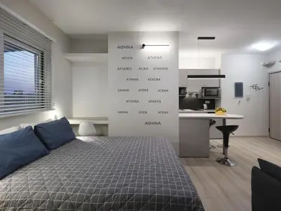 a bedroom with a bed and a kitchen at Iliodorou2-4 in Athens