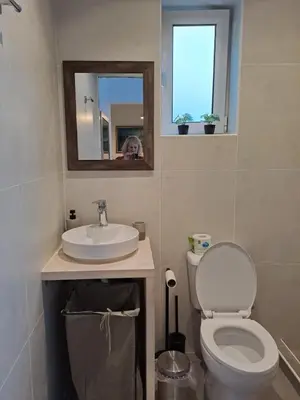 a bathroom with a toilet and a sink and a mirror at ANAFIS COZI in Athens