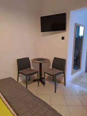 a room with two chairs and a table and a tv at ANAFIS COZI in Athens