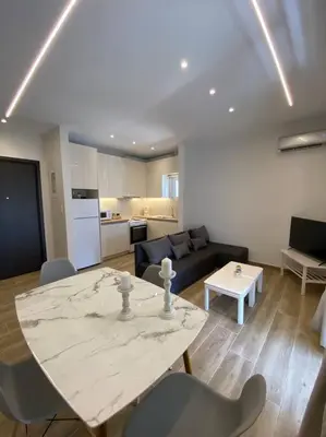 a living room with a table and a couch at Sea Through Apartment Anavissos in Anavissos