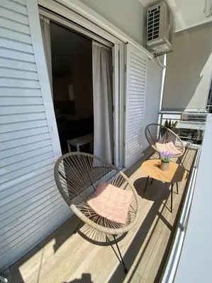 two chairs and a table on a balcony at Sea Through Apartment Anavissos in Anavissos