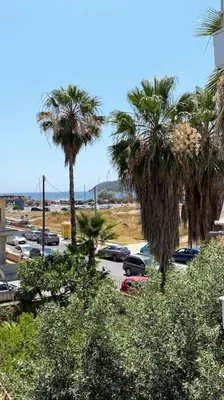a view of a parking lot with palm trees at Sea Through Apartment Anavissos in Anavissos