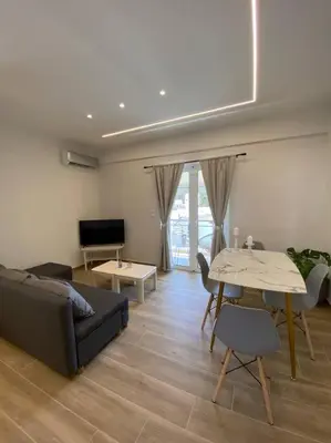 a living room with a couch and a table at Sea Through Apartment Anavissos in Anavissos