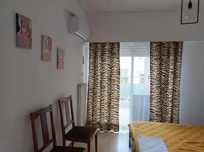 a bedroom with a bed and a window with curtains at VOULIAGMENI RIVIERA center between Beach and Lake in Athens