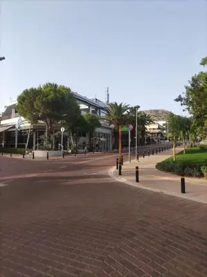 a street with a brick road with trees and buildings at VOULIAGMENI RIVIERA center between Beach and Lake in Athens