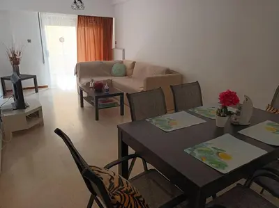 a living room with a table and chairs and a couch at VOULIAGMENI RIVIERA center between Beach and Lake in Athens