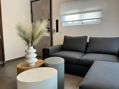 a living room with a couch and a vase at White House Vouliagmeni 1- 2BD Free Parking, Next to the Sea in Athens